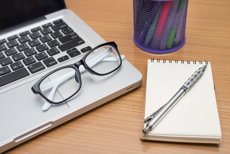 空白的商务笔记本电脑 笔 注意和木制的桌子上的眼镜