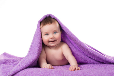 刚出生的婴儿躺和微笑在紫色的毛巾