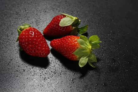 新鲜草莓与水落在黑色的背景