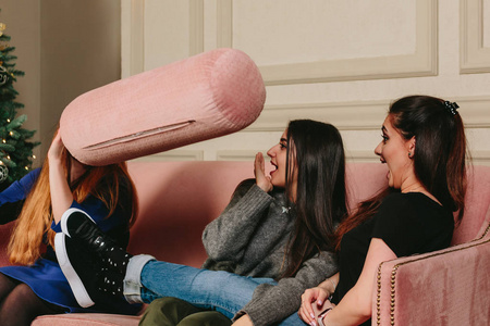 个 三个年轻漂亮的女孩扔枕头.工作室水平的特写肖像 相似素材图片