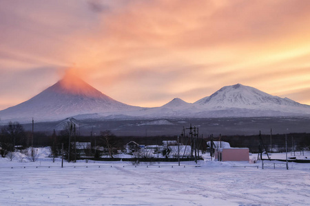 夕阳已点燃火山灰烬。俄罗斯堪察加半岛。克柳奇村