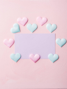 紫色的粉彩卡和粉色带纹理的背景上的心