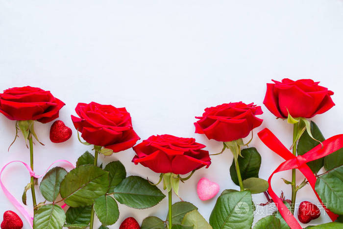 红玫瑰和装饰的心在情人节那天的白色背景