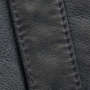 黑色皮革背景装饰带缝，缝针