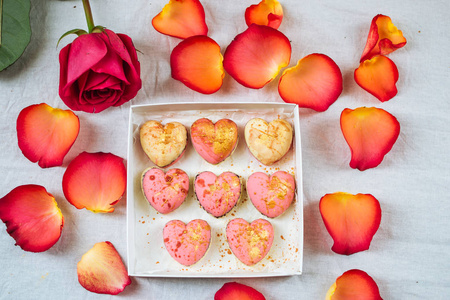 一盒糖果在形式的周围的花瓣和玫瑰的心