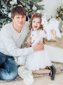 父亲和他的小女儿附近圣诞树