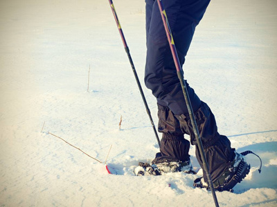 人与雪的双腿在雪中散步。详细的冬季徒步在雪堆里