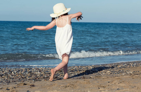 白色礼服走大海独自一人在海边玩耍的小女孩
