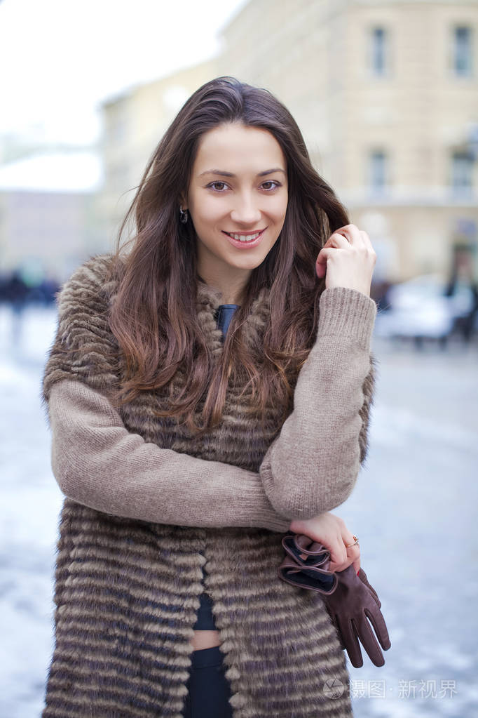 年轻漂亮的女人，穿着时尚貂皮大衣