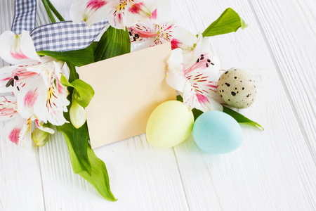 在白色的木桌上美丽的鲜花和 g 的复活节彩蛋