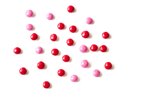 丰富多彩的红色和白色背景上的粉红色糖果