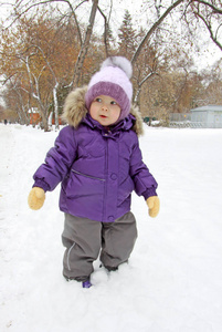 孩子在丁香冬天的衣服站在雪中公园