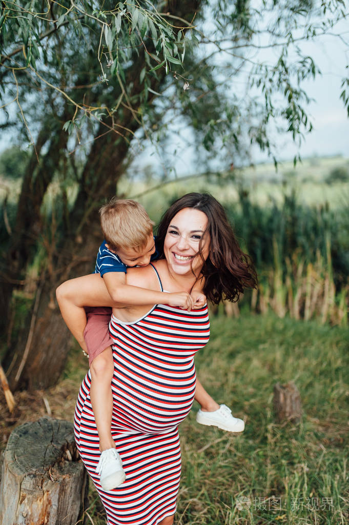 怀孕的女人与她的儿子拥抱