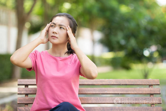 女人有头疼痛在花园里