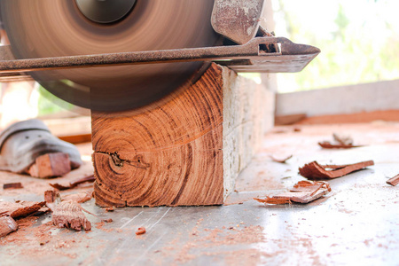 工人使用电动圆锯锯切割木头照片
