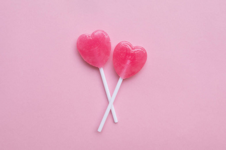 单粉红情人节一天心中塑造空柔和的粉红色纸张背景上的糖果。爱的概念。顶视图。极简主义多彩时髦风格