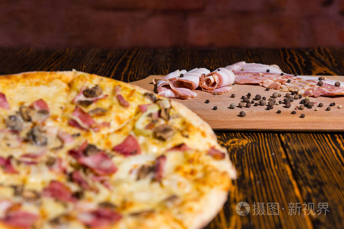 美味的比萨，在木桌子上，重点放在切菜板配培根