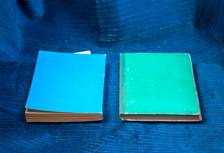 蓝色的布上的精装书。回到学校。复制空间