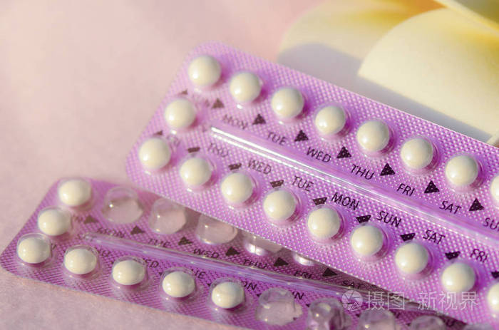 口服避孕药与素馨花粉红色楣布上