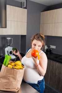 一袋新鲜水果和蔬菜的孕妇