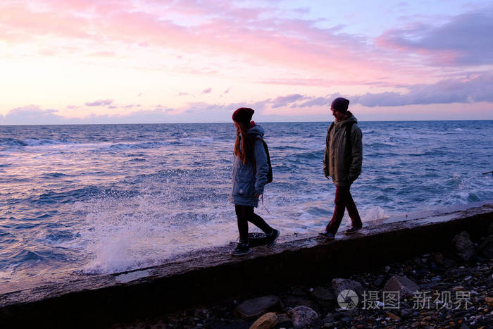 年轻夫妻沿着岸边散步