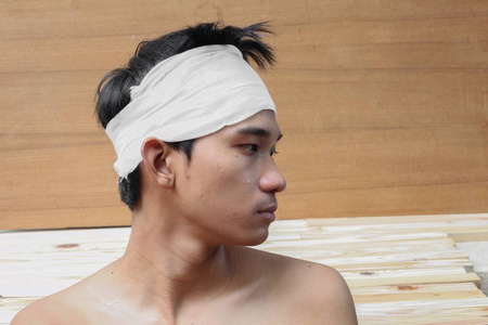 头部外伤的年轻人。由医用绷带 肖像