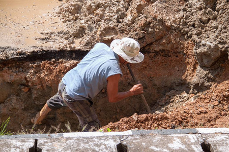 选择性对焦工人在道路上挖洞管道维修