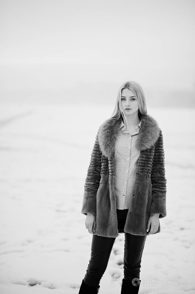 在毛皮大衣背景年轻优雅金发女郎的肖像