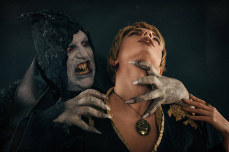 古兽吸血鬼恶魔咬一个女人的脖子.万圣节得到照片