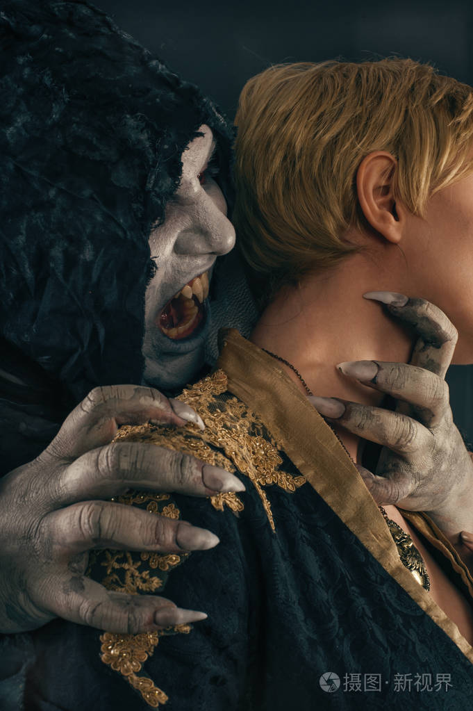 古兽吸血鬼恶魔咬一个女人的脖子.万圣节得到