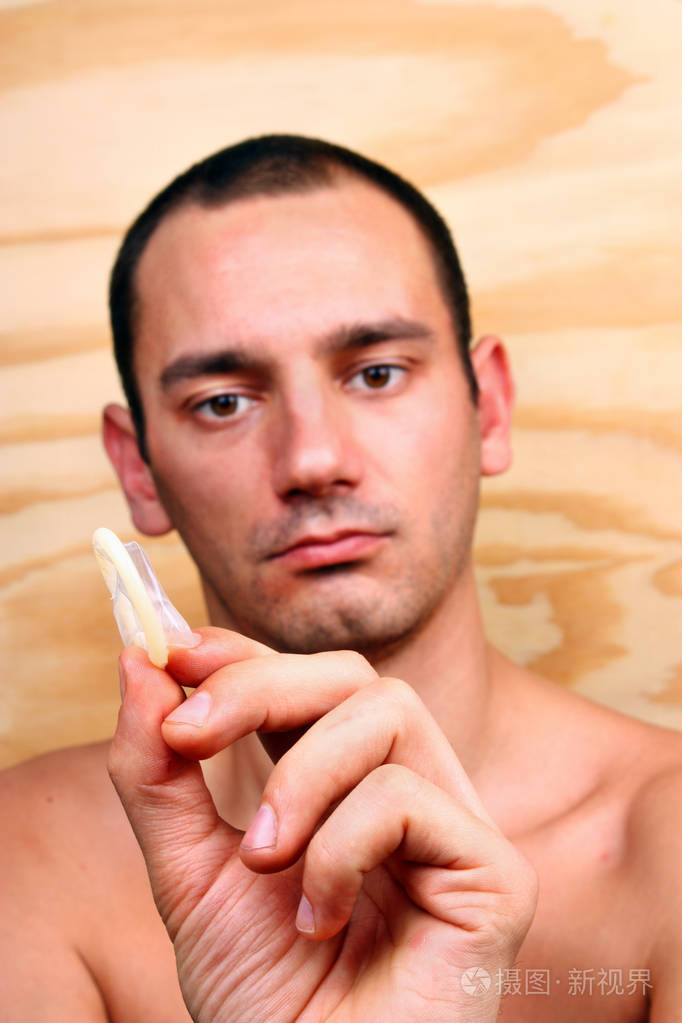 年轻英俊的男孩显示和保持安全套