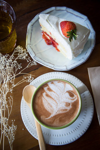 在咖啡厅与木材背景咖啡杯子和草莓蛋糕