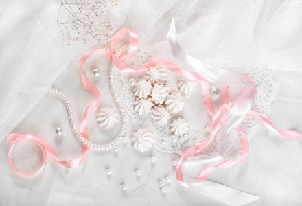 婚礼背景与珍珠 粉色和白色缎丝带和花边的法国酥饼干，平躺