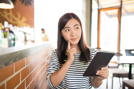 女人打字平板电脑在咖啡馆