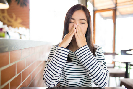 女人有打喷嚏在咖啡馆里