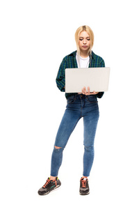 年轻的金发女子，手里拿着一台笔记本电脑