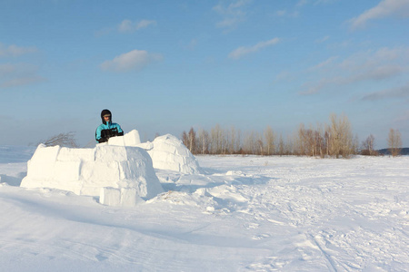 人在冬天盖一座冰屋的林间空地上的雪块