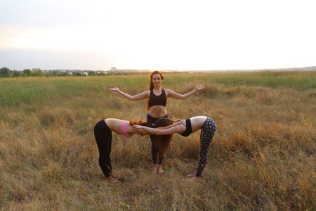 女性练瑜伽姿势，站两个女孩，弯曲和鹅肝
