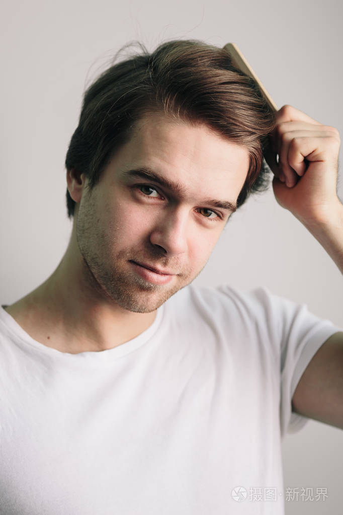 拿着梳子的健康头发的男人