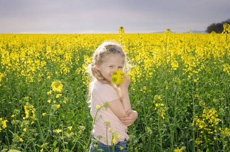 小孩在风景秀丽的黄色油菜花田