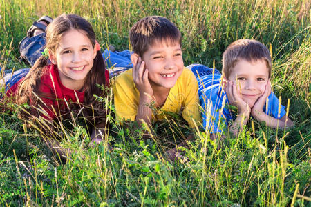 三个微笑的孩子在草地上