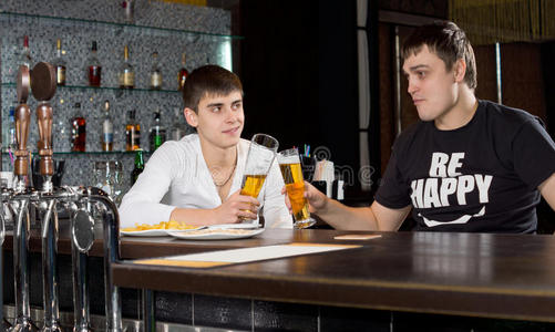 两个年轻人在啤酒上互相敬酒