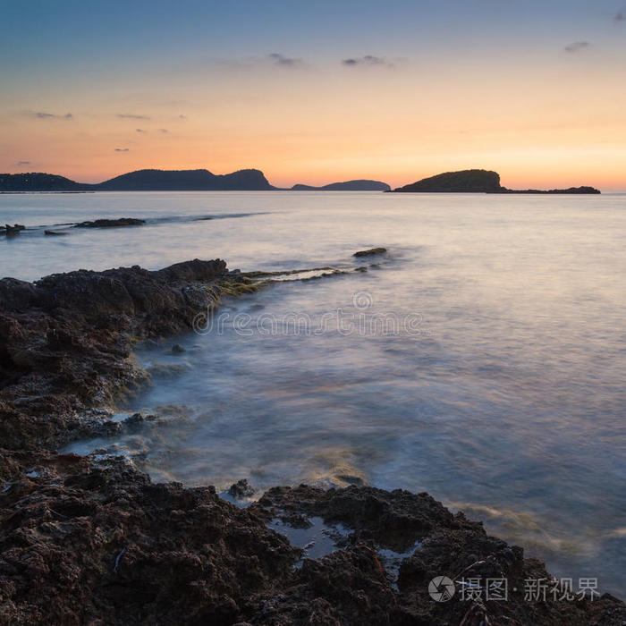 美丽的风景黎明日出与岩石海岸线和长期经验