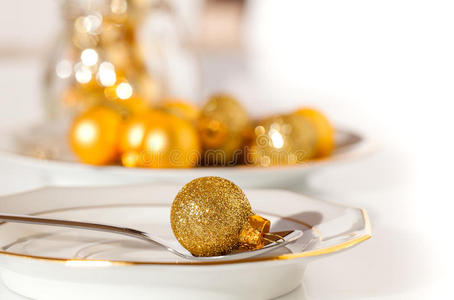 用金色圣诞饰品装饰的银色餐具
