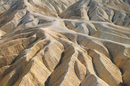 死亡谷金色峡谷严重侵蚀的山脊明亮的太阳落在犹他州山谷的山后.