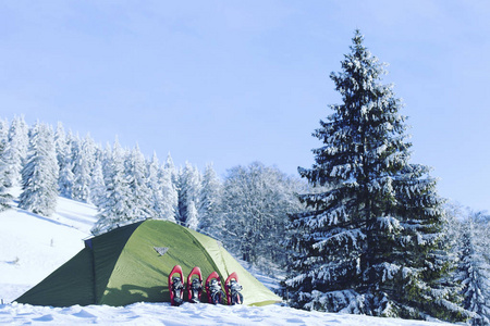 冬季徒步旅行。在山里徒步旅行带着背包和帐篷雪的冬天