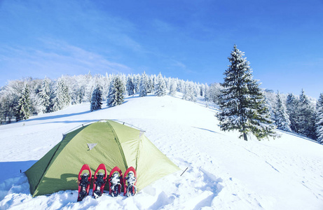 冬季徒步旅行。在山里徒步旅行带着背包和帐篷雪的冬天