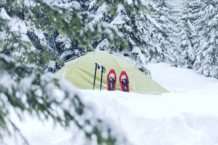 冬季徒步旅行。在山里徒步旅行带着背包和帐篷雪的冬天