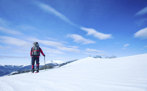 冬季徒步旅行。在山里徒步旅行带着背包和帐篷雪的冬天