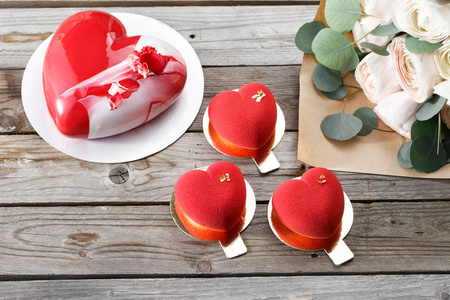 红色的心 cacke 甜点和毛茛属植物上木制的背景。早餐在情人节甜点